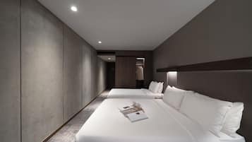 A modern hotel room with two beds, a walk-in closet, and a hallway.