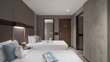 A hotel room with two beds, a plush toy, a magazine, and a wooden door.