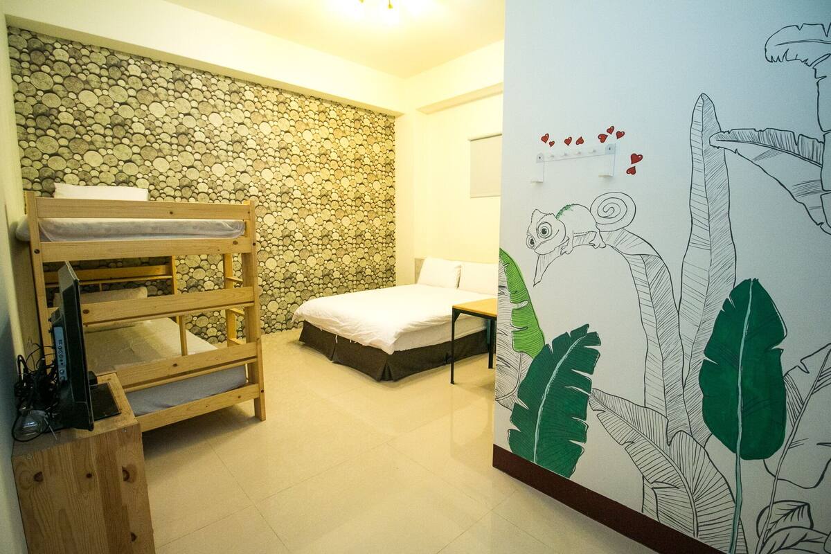 A room with a bunk bed, a single bed, a stone wall, and a wall with a leaf pattern.