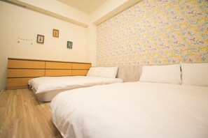 A bedroom with two beds, a wooden headboard, and a floral-patterned wall. - Happy Hi B&B (Taitung)