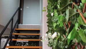 Una escalera de madera con barandillas negras que conduce a una habitación con una puerta blanca.