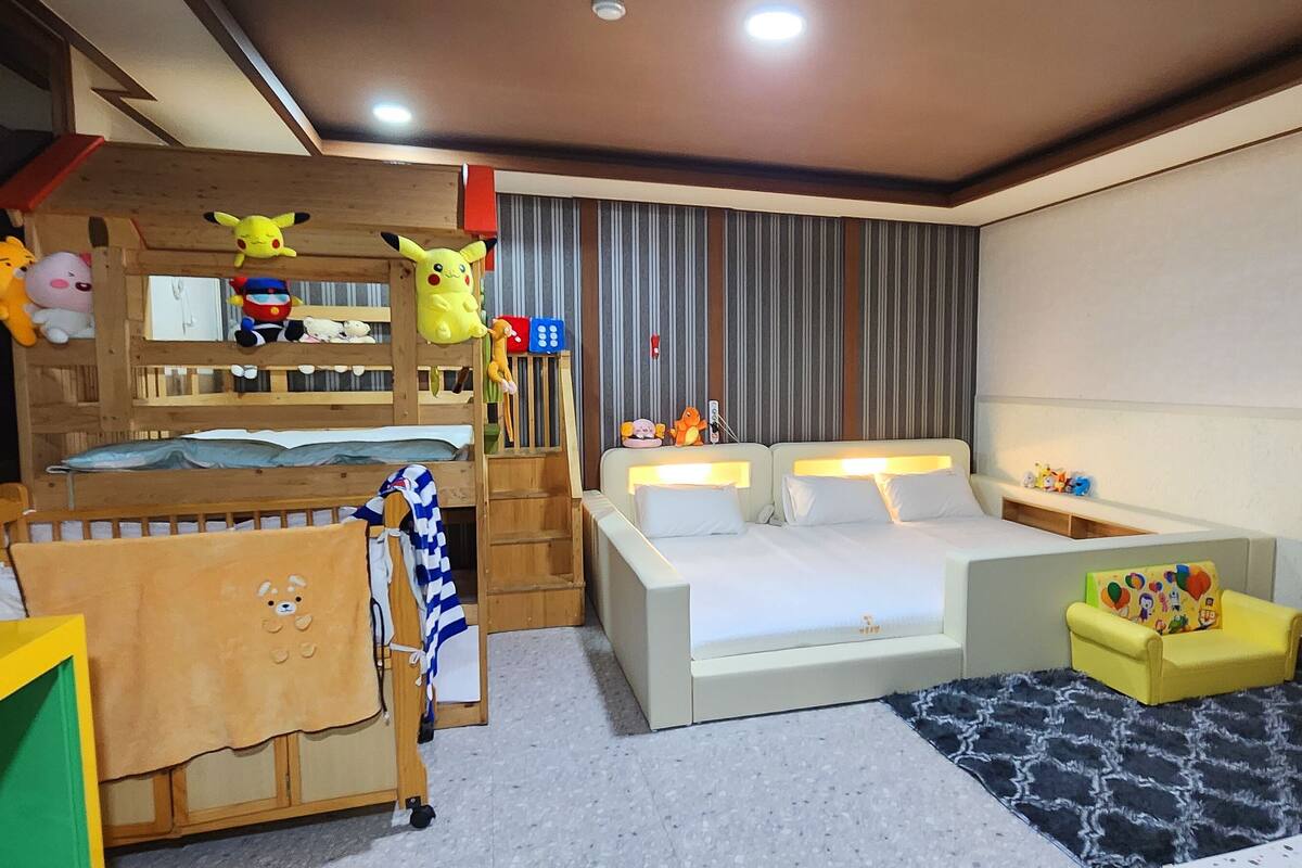 Habitación ideal para niños, con literas, zona de juegos y una cama grande con mesita de noche.