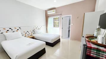 A hotel room with two beds, a bathroom, and a dining area with a table and chairs.