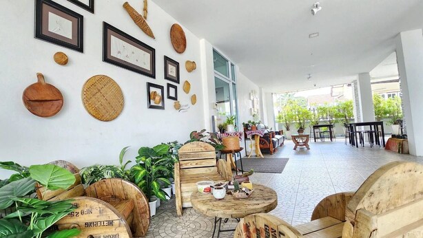 A spacious indoor area with wooden furniture and potted plants. - Thanaphat Place (Lam Plai Mat)