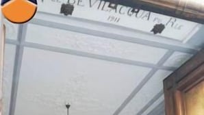 Interior de hotel con un gran arco, una araña y un letrero con el nombre del hotel.