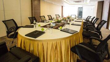 A conference room with a round table, black chairs, and a yellow tablecloth.