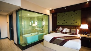 A modern hotel room with a large bed, a glass-enclosed bathroom, and a decorative wall panel. - Royale Signature Hotel (Alor Setar)