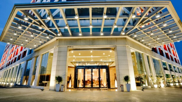 A modern hotel entrance with a glass canopy, large windows, and a well-lit facade. - Royale Signature Hotel (Alor Setar)