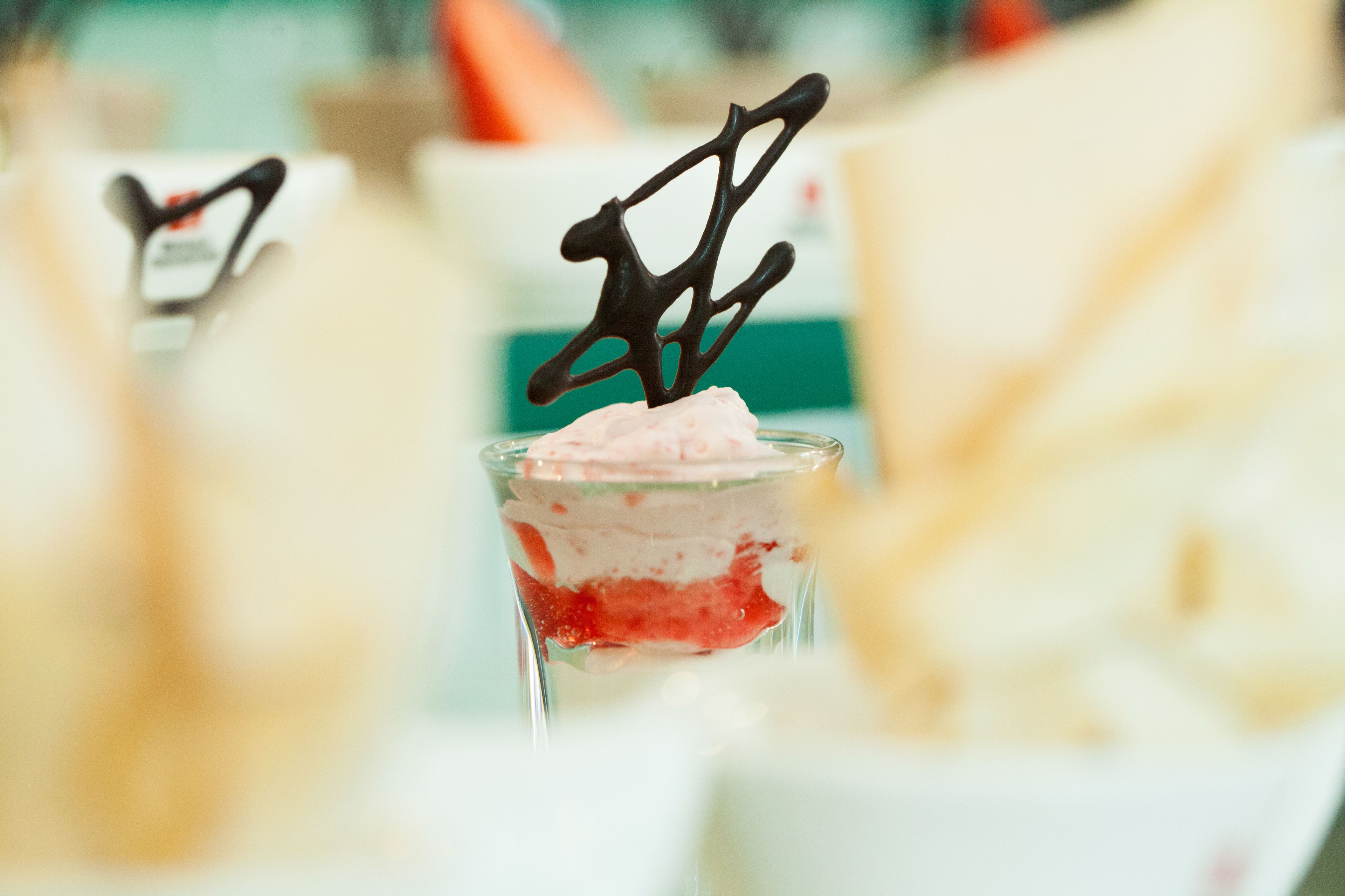 Un postre con decoración de chocolate en una copa de cristal transparente.