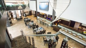 A modern hotel lobby with a central bar, seating areas, and a staircase. - Royale Signature Hotel (Alor Setar)