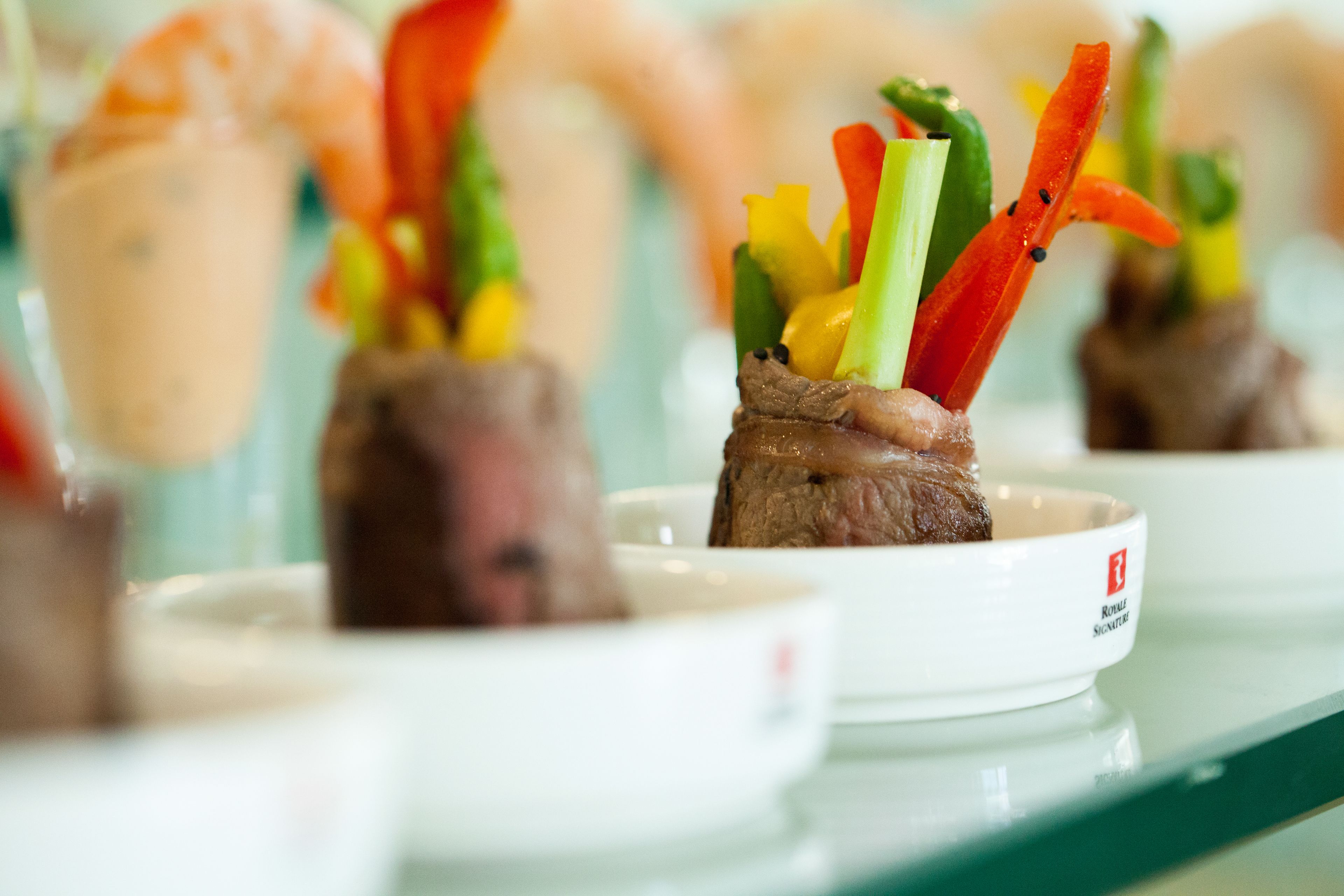 A series of dishes with meat and colorful vegetables on a white plate.