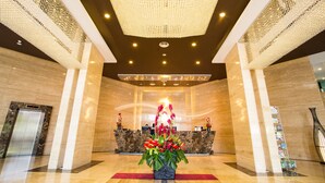 A lobby with a reception desk, a large chandelier, and a floral arrangement. - Royale Signature Hotel (Alor Setar)