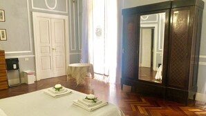 Habitación de hotel con cama, una mesa redonda, un espejo y un armario.