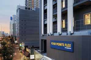 Un edificio moderno con un cartel que dice 'FOUR POINTS FLEX BY SHERATON'.