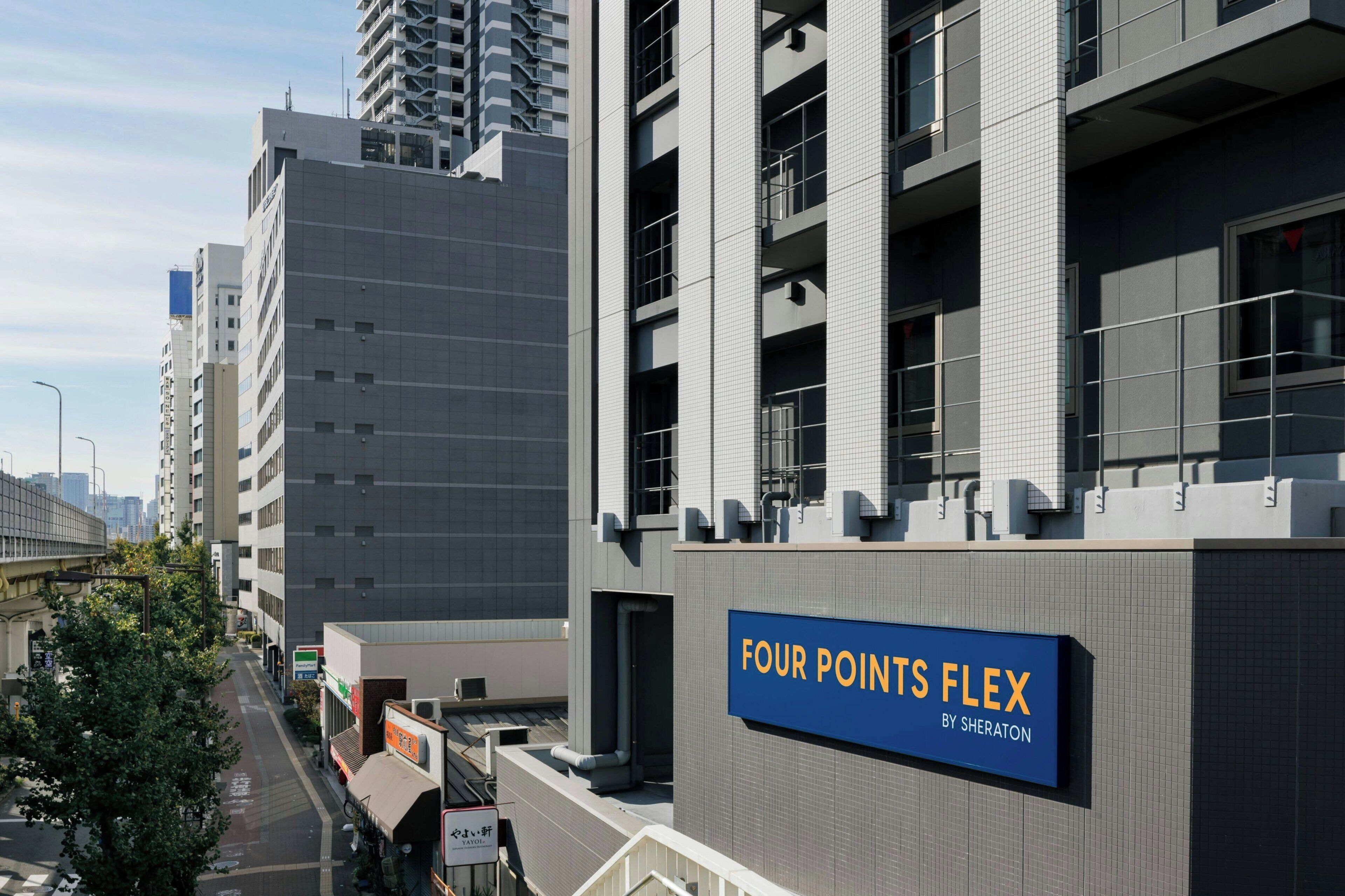 A modern building with a sign reading 'FOUR POINTS FLEX BY SHERATON'.
