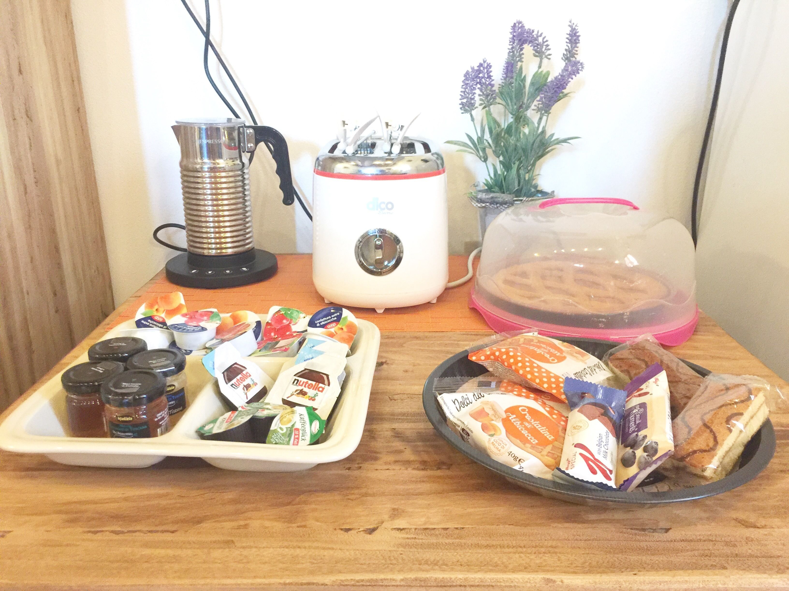 A breakfast tray with Nutella, a coffee maker, a toaster, and a plant.