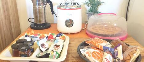 A breakfast tray with Nutella, a coffee maker, a toaster, and a plant.