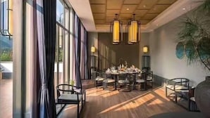 A dining area with a round table, chairs, and pendant lighting. - The Lucid Resort (Taizhou)