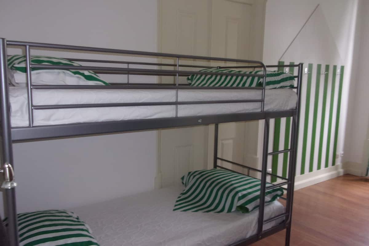 A bunk bed with green and white striped bedding.