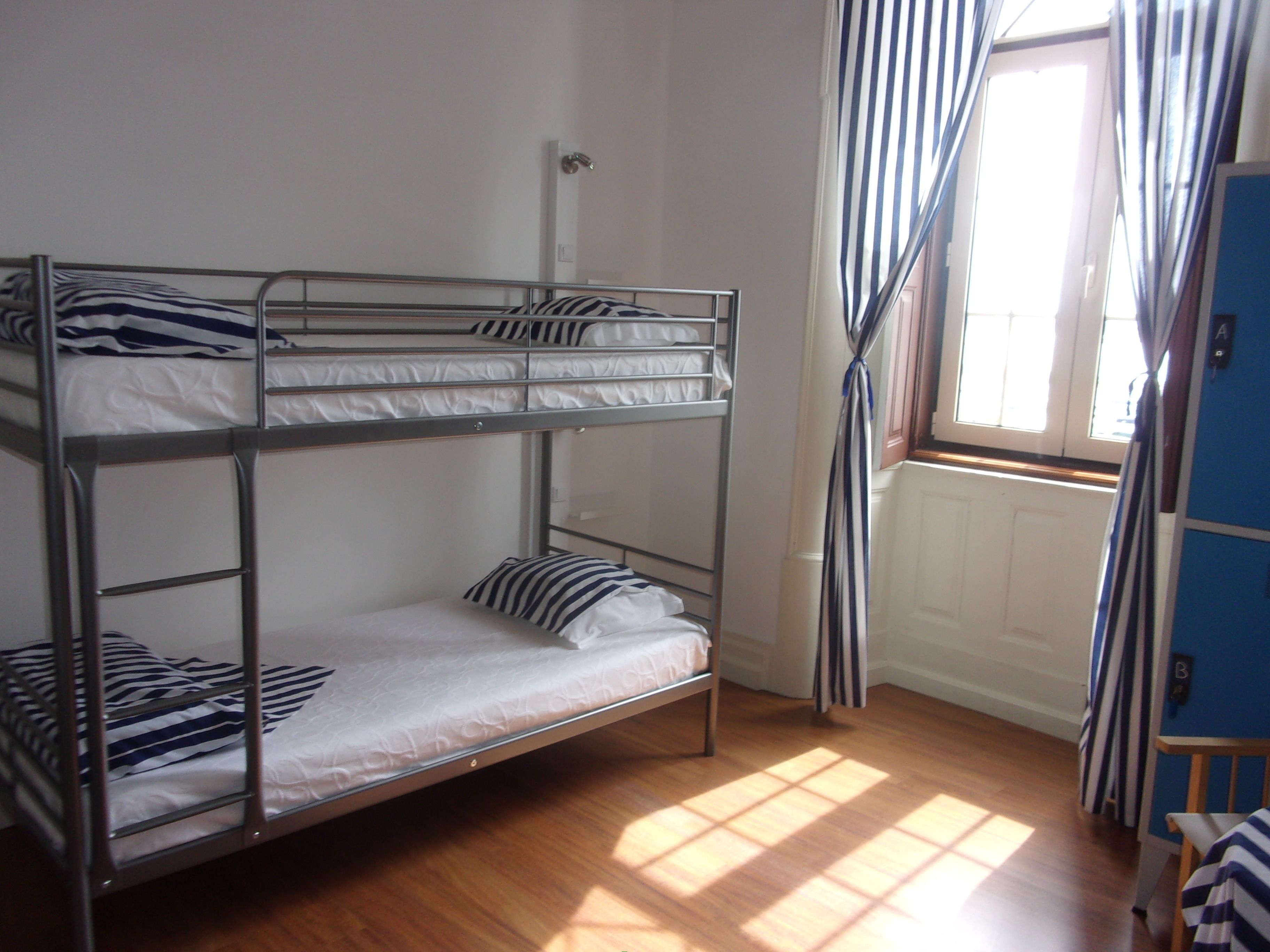 A bunk bed room with a window and curtains.