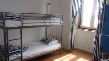 A bunk bed room with a window and curtains.