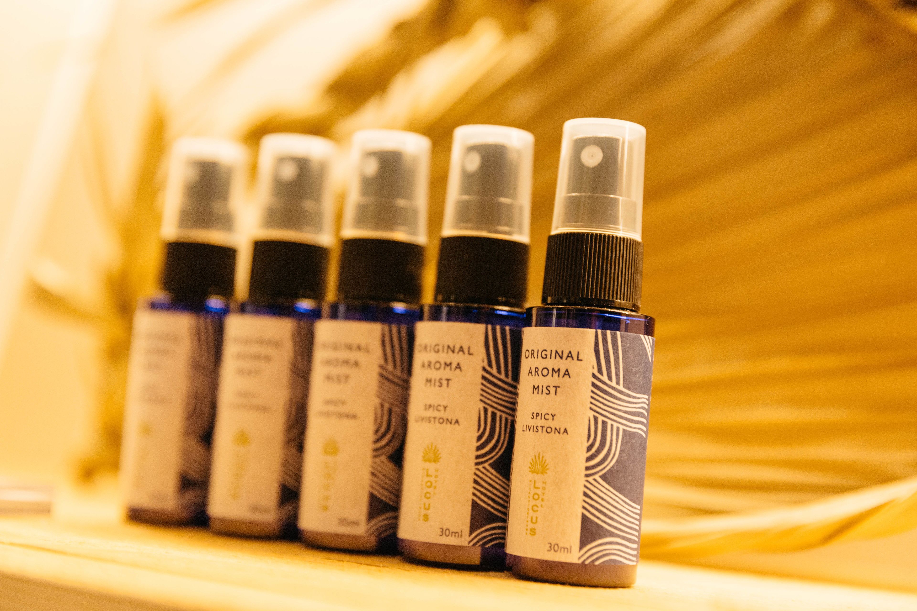A row of identical bottles with labels, arranged on a surface.