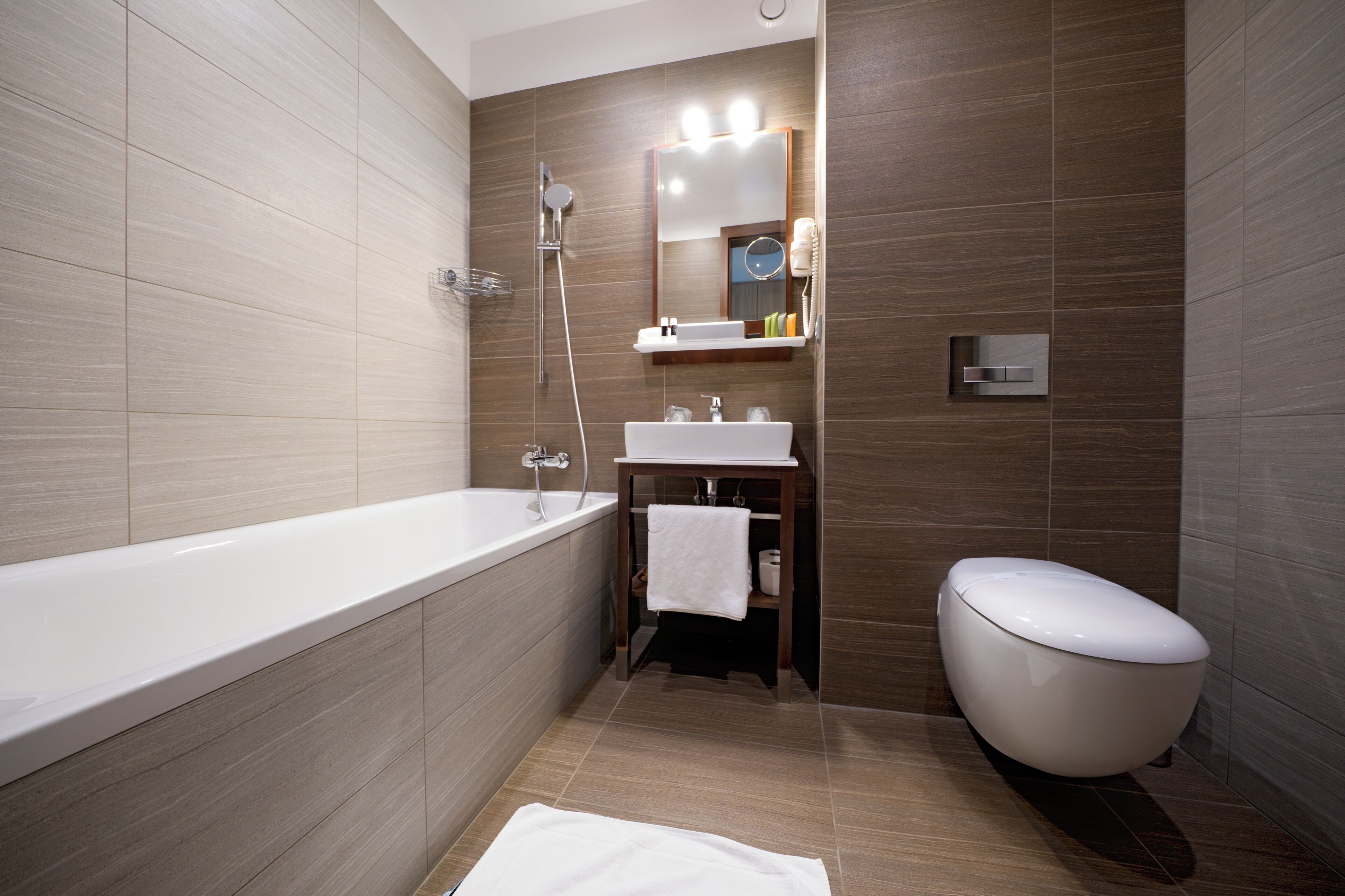 A modern bathroom with a bathtub, sink, and toilet.