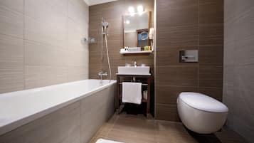 A modern bathroom with a bathtub, sink, and toilet.