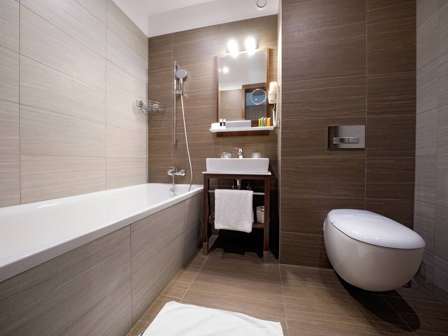 A modern bathroom with a bathtub, sink, and toilet.