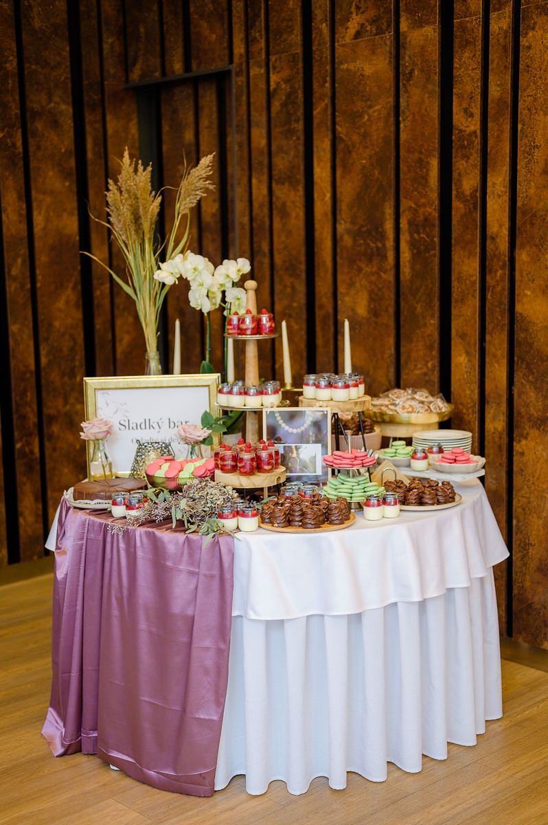 Una mesa de buffet con diversos alimentos y un letrero que dice "Sladky bar".