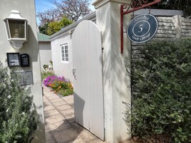 Una entrada cerrada a una cabaña de huéspedes con un letrero que dice 'Apple Bee 5 Guest Cottage'.