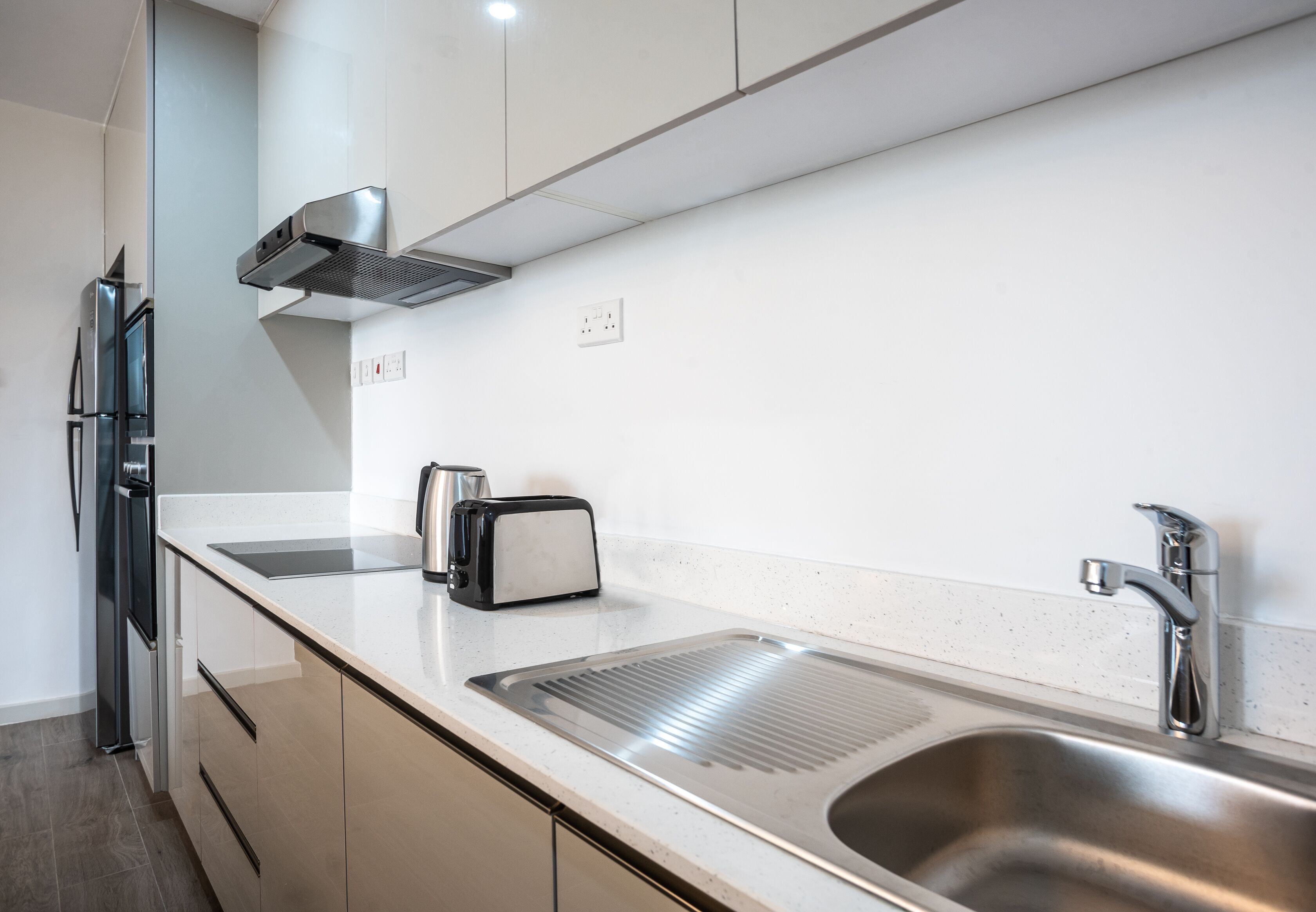 Een moderne keuken met roestvrijstalen apparatuur, een inbouwspoelbak en een broodrooster.