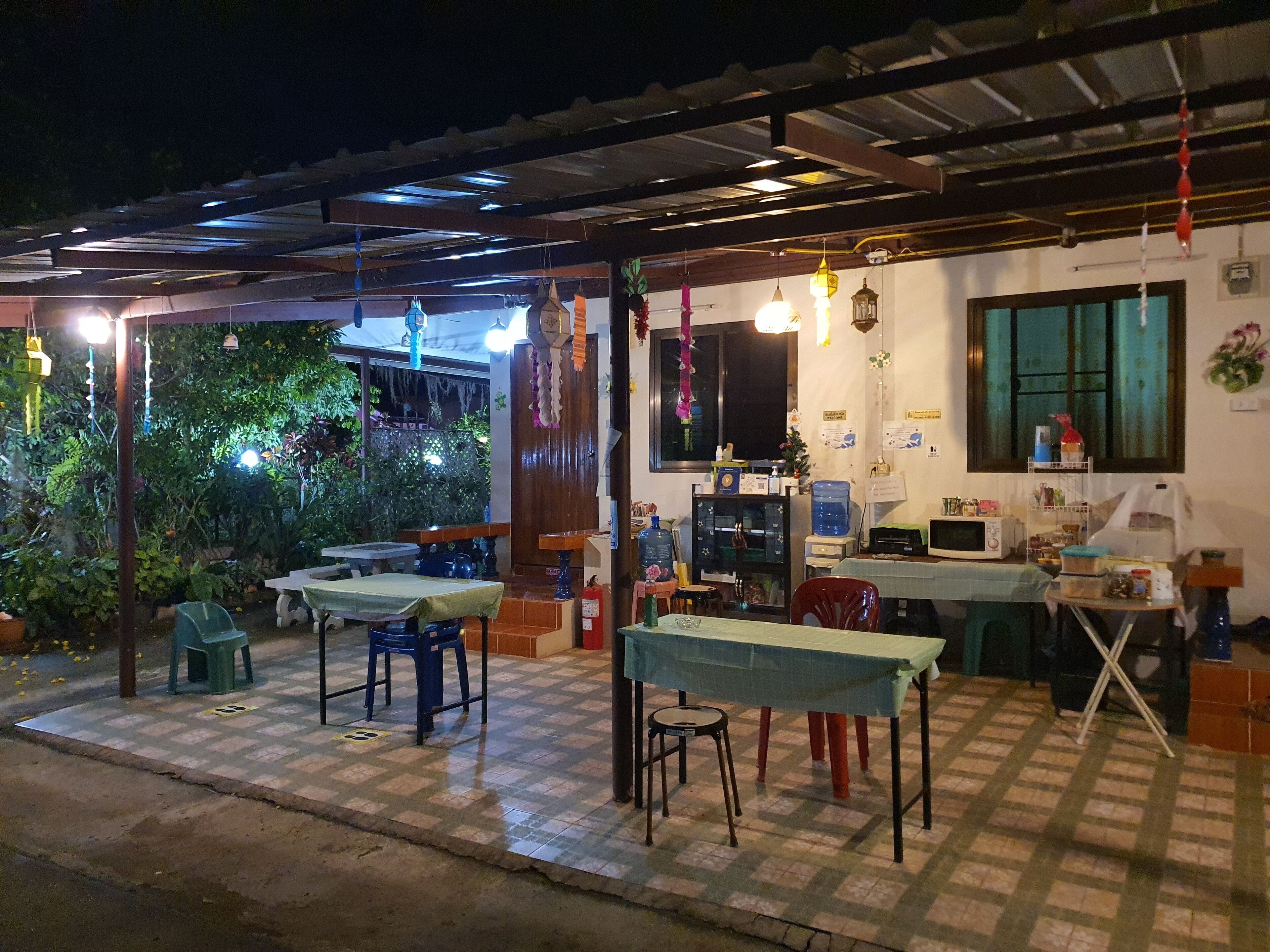 An outdoor dining area with tables and chairs, a water dispenser, and a fire extinguisher.