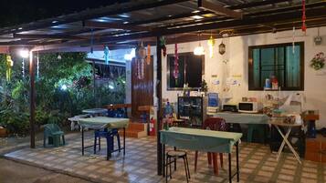 An outdoor dining area with tables and chairs, a water dispenser, and a fire extinguisher.