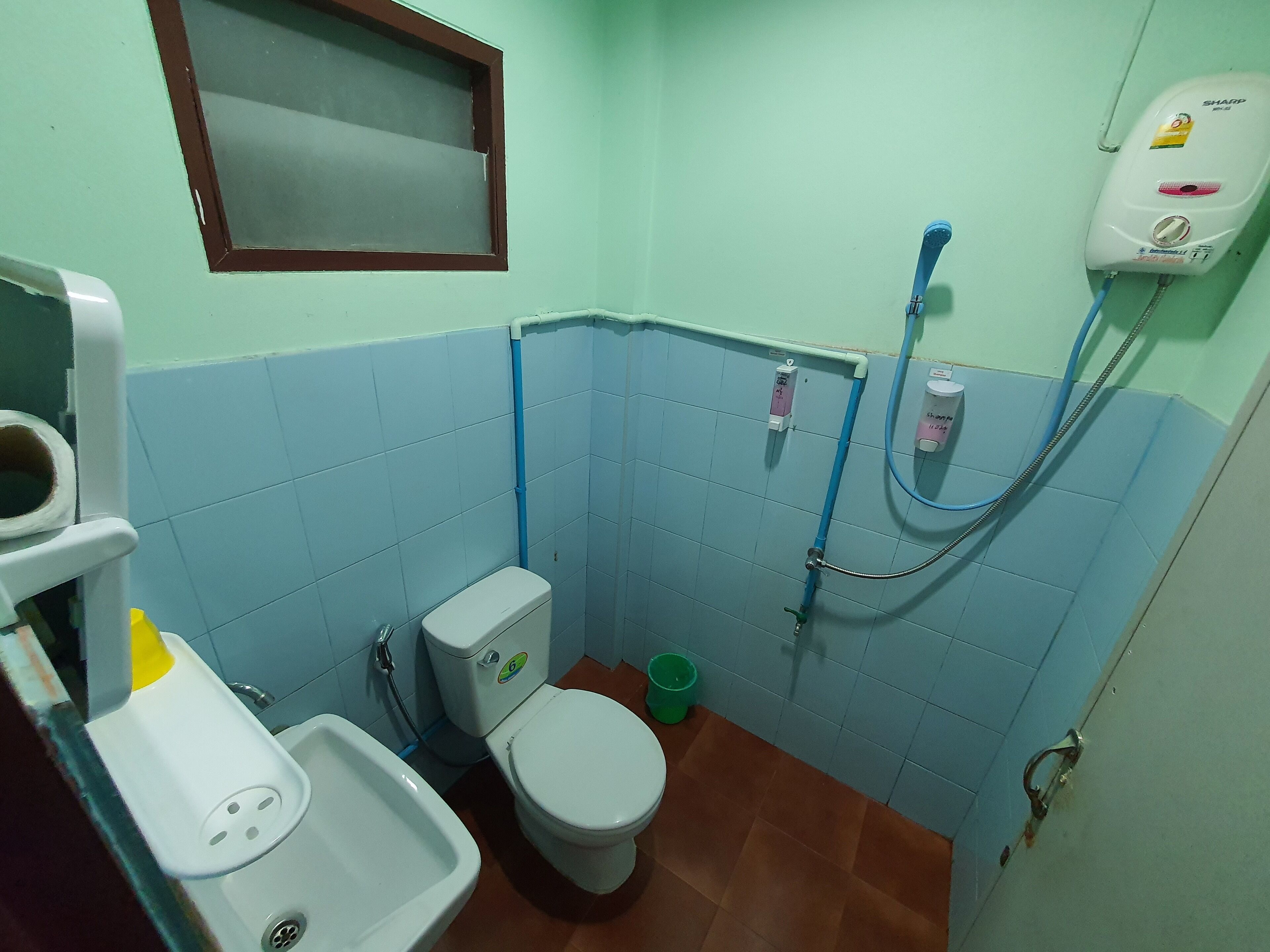 A small bathroom with a toilet, sink, and shower.