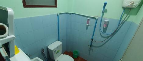 Un baño pequeño con inodoro, lavabo y ducha.