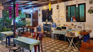 A cozy, well-lit room with a checkered floor, wooden furniture, and various kitchen appliances.