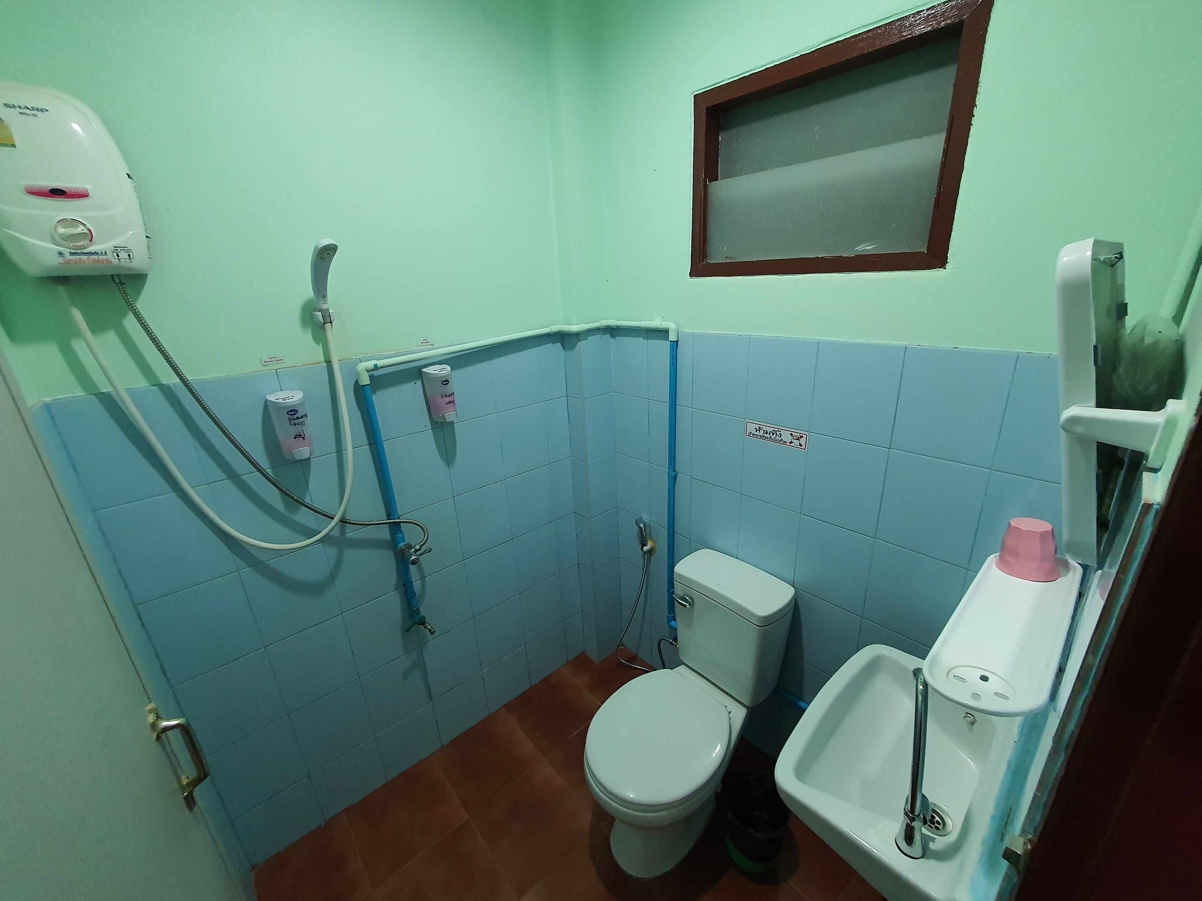 A small bathroom with a toilet, a sink, and a shower.