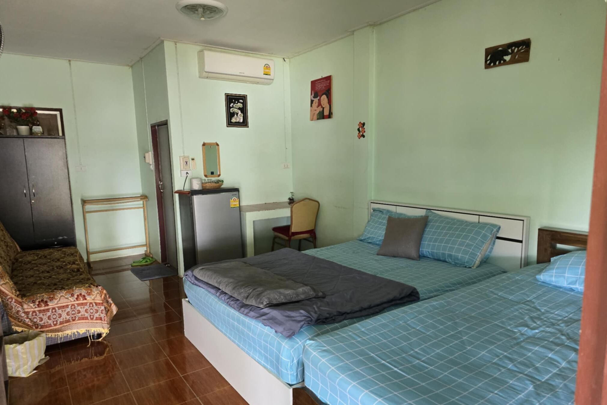 Un dormitorio con dos camas, un escritorio, una silla y un armario.