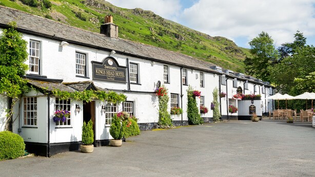 A white building with a sign reading "Kings Sweeney's Head Hotel."