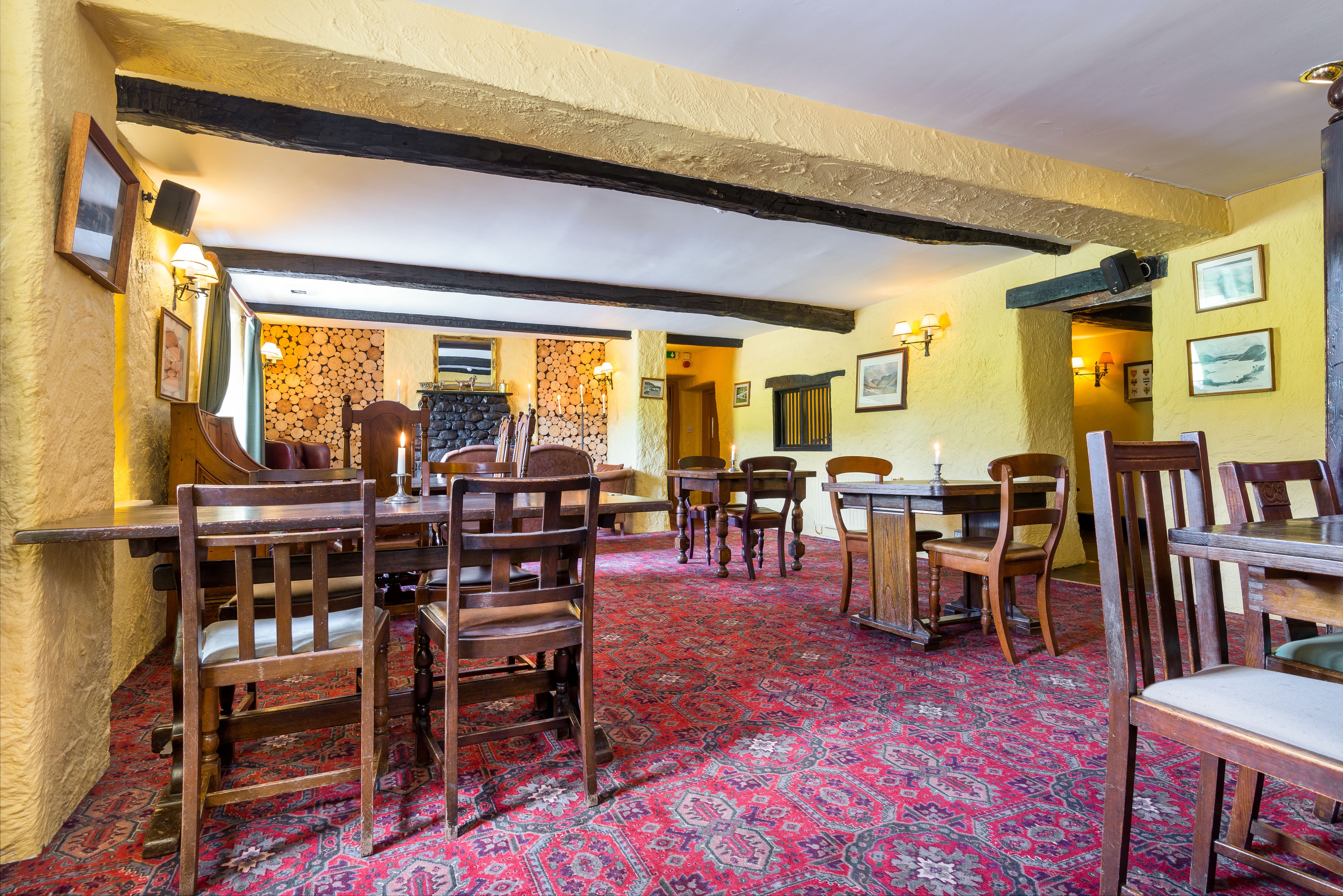 A traditional inn with wooden furniture, a patterned carpet, and exposed beams.