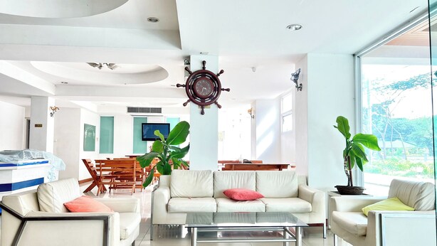 A modern living room with a sofa, armchairs, a coffee table, and a dining area with chairs and a table. - BT Grand Condotel (Udon Thani)