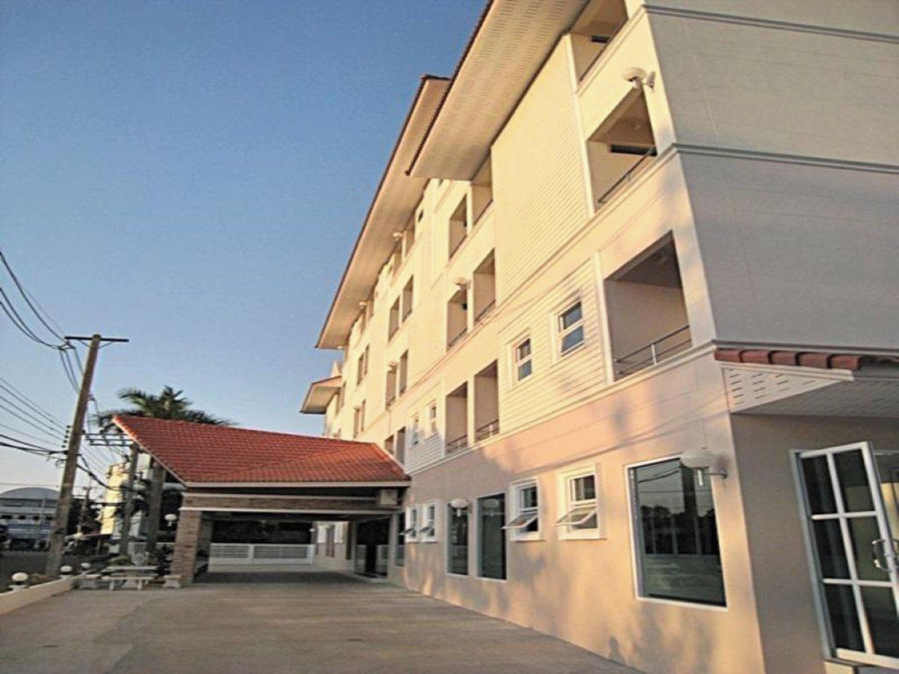 A multi-story building with a flat roof and a covered entrance.