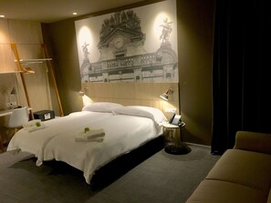 Une chambre d’hôtel avec un grand lit, des lampes de chevet, un bureau et une chaise.
