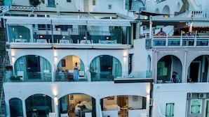 A multi-level hotel with outdoor seating areas, a pool, and a dining terrace. - Kratiras View Luxury Suites (Santorini)
