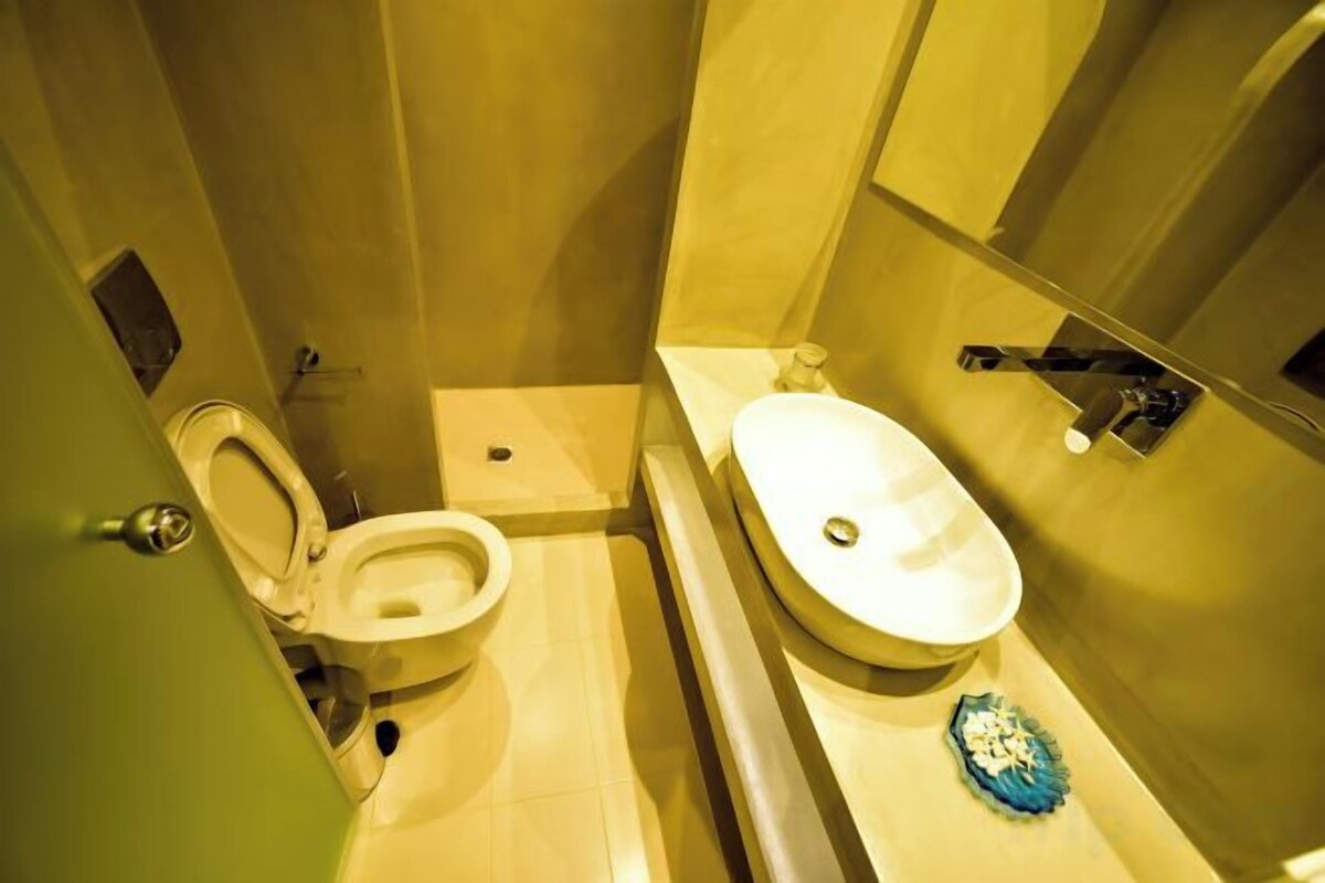 A small bathroom with a toilet, sink, and mirror.