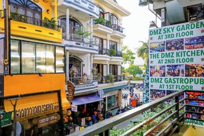 A multi-story building with balconies, a massage shop, and signs for DMZ Sky Garden, DMZ Kitchen, and DMZ GastroPub. - DMZ Hostel Hue (Hue)