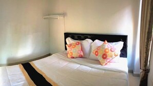 A neatly made bed with a black headboard and two decorative pillows. - The Wish Residence (Udon Thani)