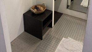 A bathroom with a black vanity, a hanging wooden rack, a woven basket, and a large mirror. - Taipei Breeze B&B (Taipei)