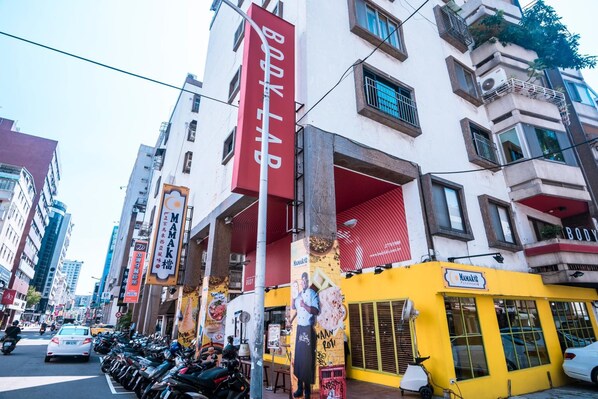 A street view with a building featuring a yellow facade and a red sign. - Taipei Breeze B&B (Taipei)